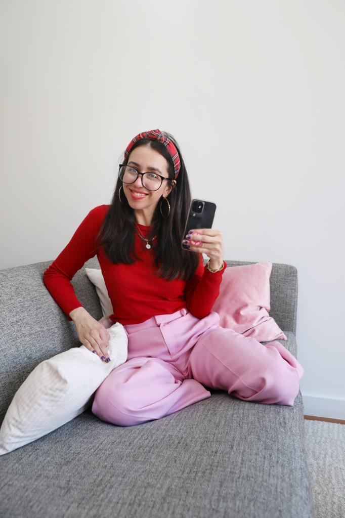 Smiling woman sitting on a couch, holding her phone